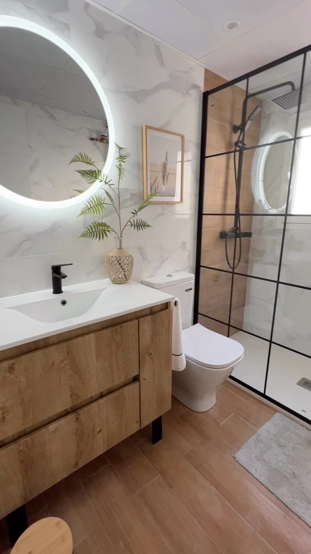 Reforma de baño con mármol blanco, ducha y mueble de madera